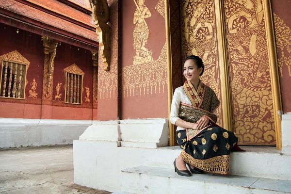 Ein laotisches Mädchen in traditioneller Kleidung in einem Tempel.